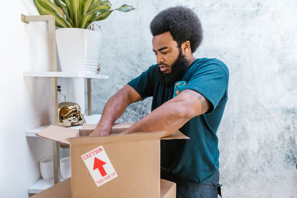 A packer wrapping a fragile item before putting it in a carton
